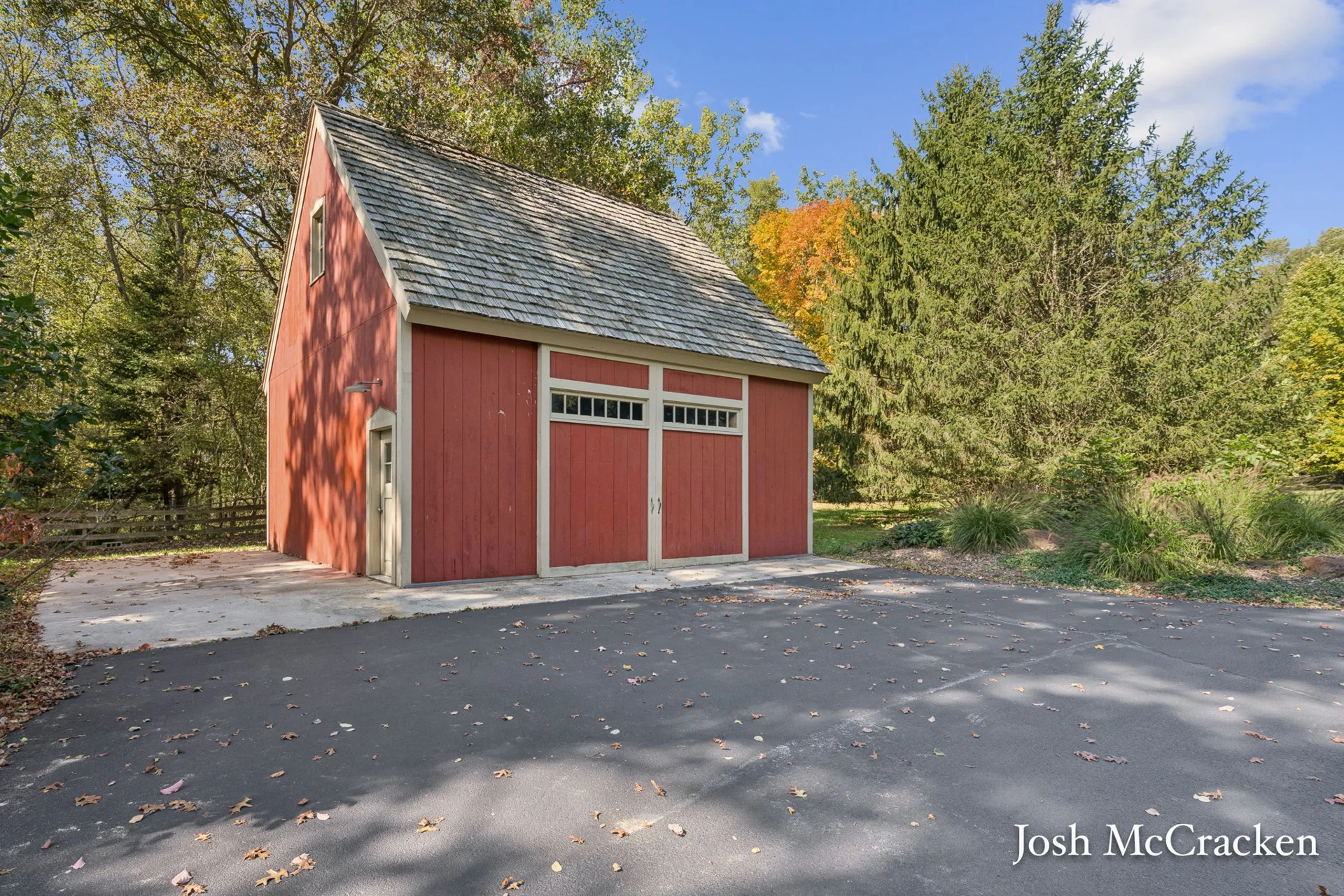 Red barn framed by mature trees