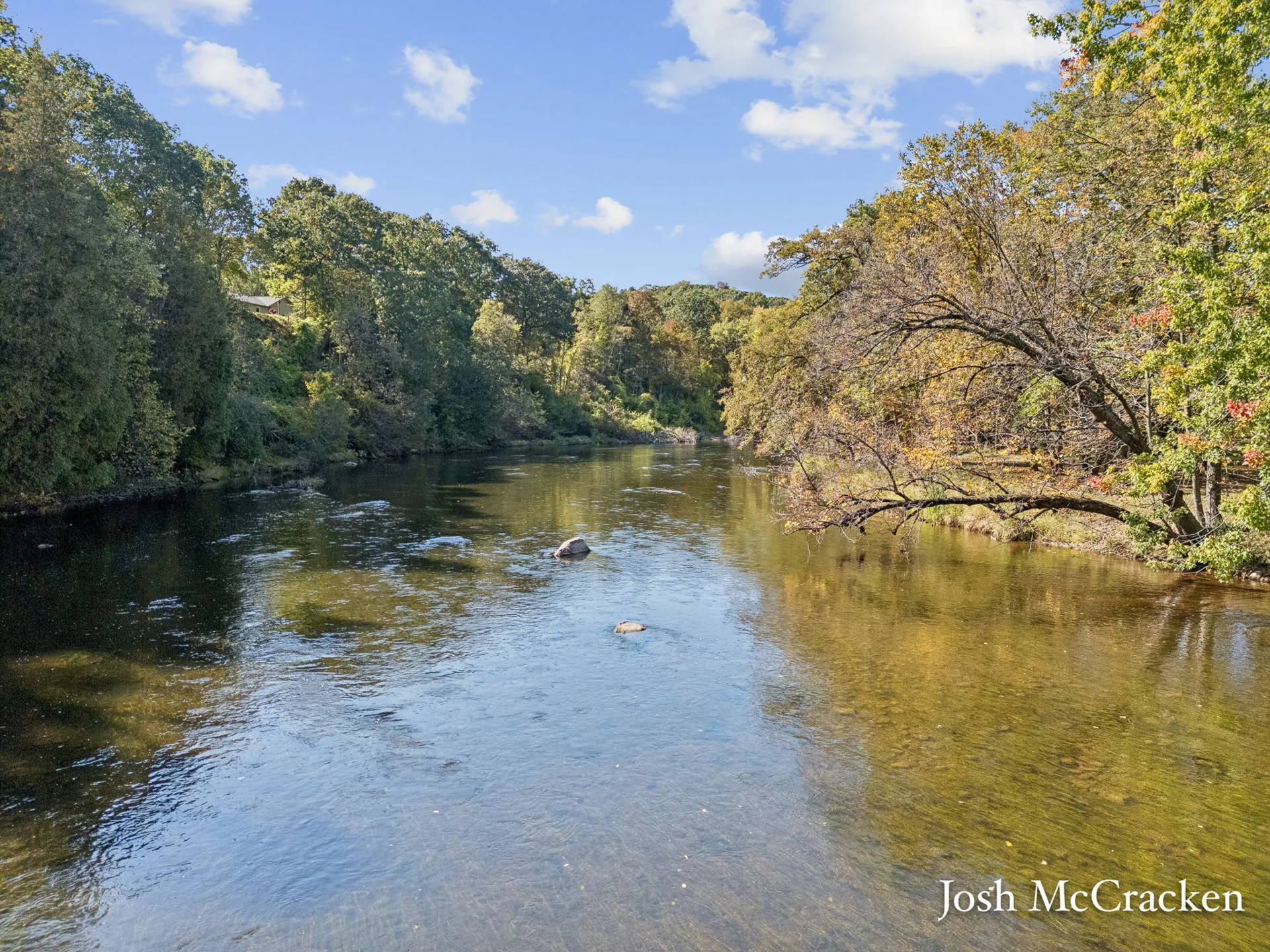 The Flat River bordered by trees in autumn