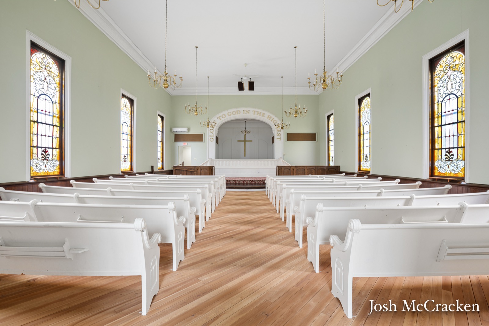 The renovated sanctuary at 404 N Hudson Street SE, Lowell, Michigan, with refinished hardwood floors and original stained glass